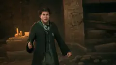 Hogwarts Legacy student exploring a candlelit castle interior with a wand